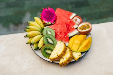 Havuz kenarındaki tropikal meyve ve çiçeklerin cansız görüntüsü