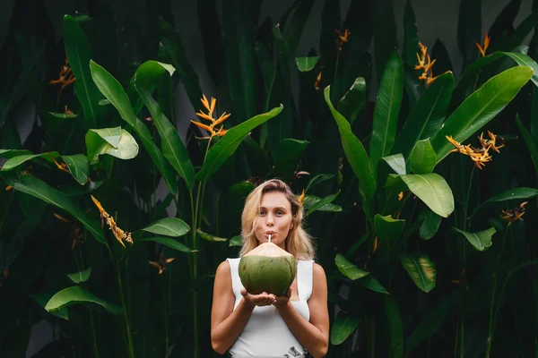 Mulher loira bonita no vestido branco no terraço tropical com coco — Fotografia de Stock