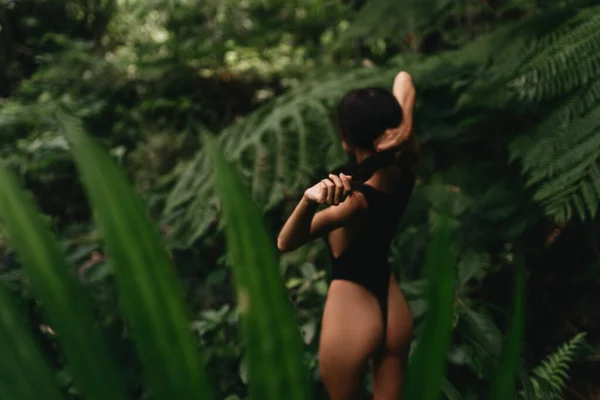 Mujer joven atractiva entre las plantas tropicales. — Foto de Stock