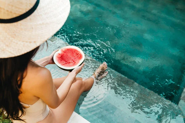 Menina segurando melancia na piscina azul, pernas finas, estilo instagram. — Fotografia de Stock