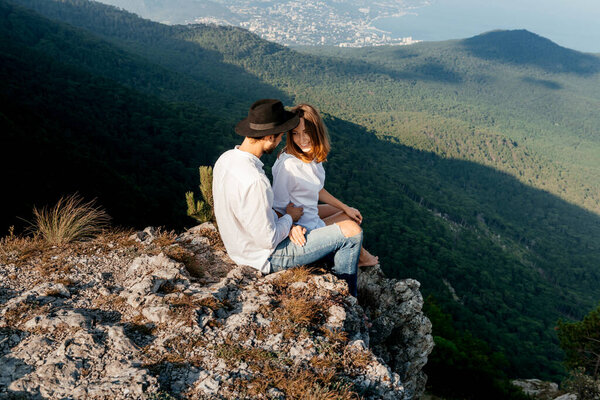 Attractive young loving couple of man and woman in the green mountain landscape