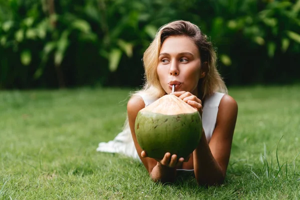 Kokosnöt och kvinnor koppla av tid på det gröna gräset. — Stockfoto