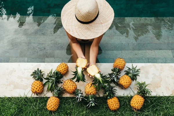Mulher bonita relaxante na piscina com abacaxis. Estilo de vida saudável, Nutrição, Dieta. férias de verão — Fotografia de Stock