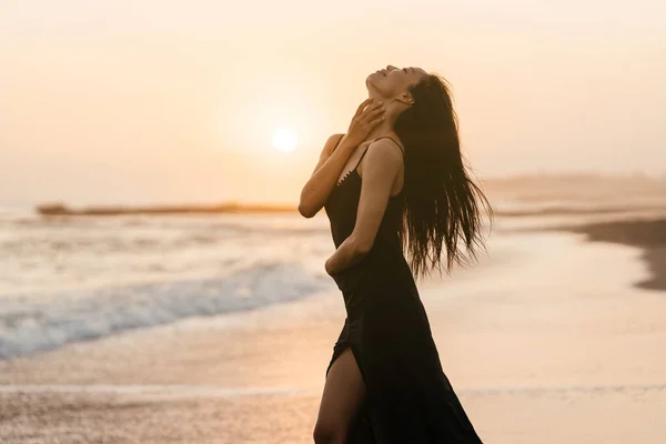 Freiheit Chinesische Frau fühlt sich frei tanzen am Strand Sonnenuntergang. — Stockfoto