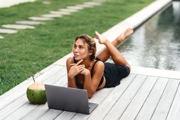 Woman freelance work typing on laptop with fresh coconut .