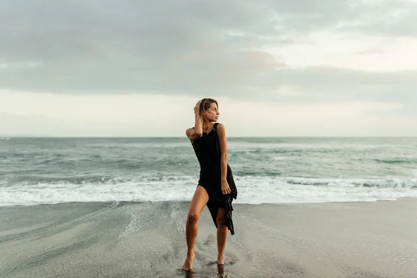 Mujer en la playa está disfrutando de la naturaleza serena del océano durante las vacaciones de viaje al aire libre —  Fotos de Stock