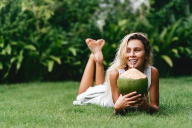Hindistan cevizi ve kadınlar yeşil çimlerde dinlenir..