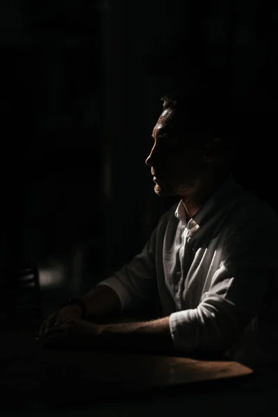 Portret mężczyzny o intensywnym spojrzeniu stojącego w ciemnym pokoju — Zdjęcie stockowe