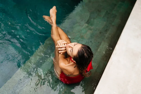 Donna in costume da bagno rosso rilassante in piscina — Foto Stock