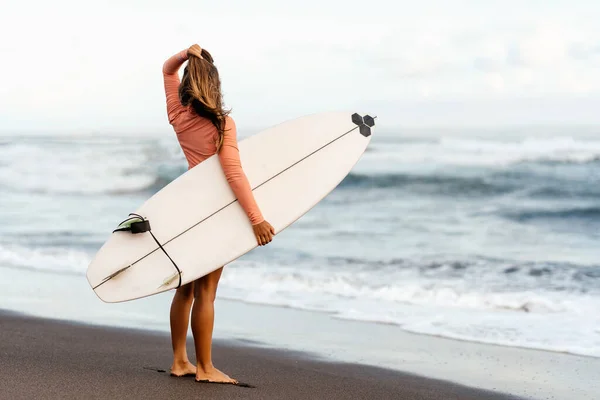 Серфингистка смотрит на синий океан — стоковое фото