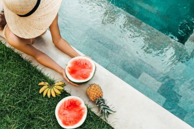 Mavi havuzda karpuz tutan kadın, ince bacaklar, instagram tarzı..