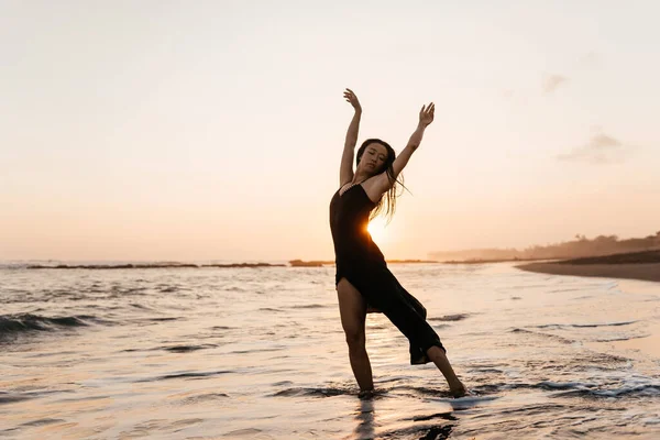 Libertad Mujer china sintiéndose libre bailando al atardecer en la playa. —  Fotos de Stock