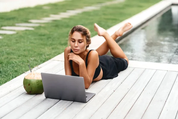 Woman freelance work typing on laptop with fresh coconut .