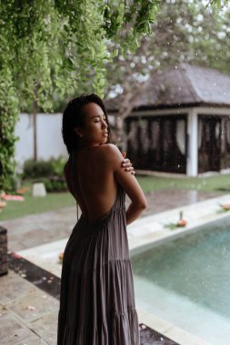 Bali 'de lüks bir villada havuzda dinlenen genç bir kadın..