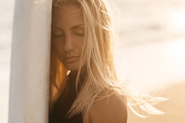 Belle femme surfeuse sur la plage au coucher du soleil — Photo