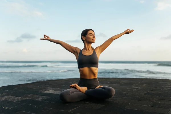 young beautiful woman meditation on beach.