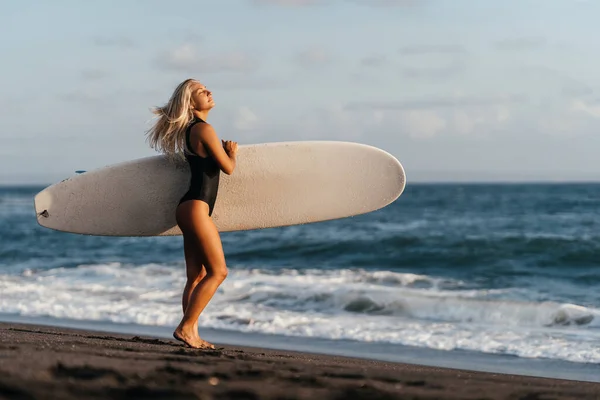 Surfista mulher com bordo na praia de areia, esportes aquáticos. — Fotografia de Stock