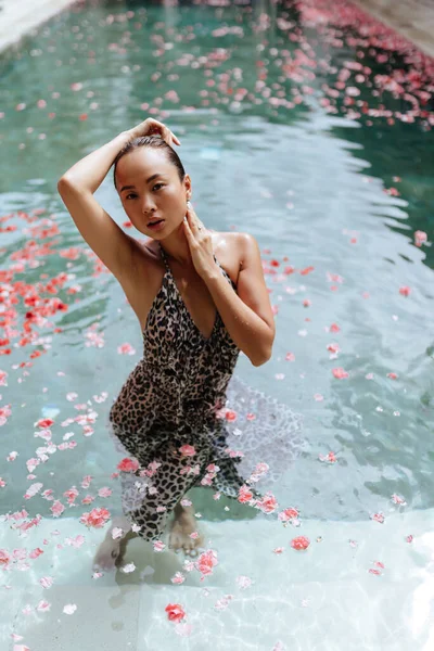 Beautiful female in swimming pool background