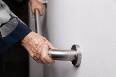 Küpeşte güvenliği için üzerinde tutan yaşlı kadın yürümek adımları