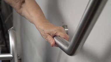 Küpeşte güvenliği için üzerinde tutan yaşlı kadın yürümek adımları