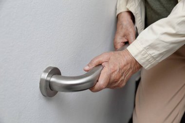 Küpeşte güvenliği için üzerinde tutan yaşlı kadın yürümek adımları
