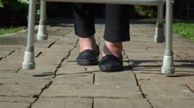 Yaşlı kadın Walker arka bahçesinde kullanarak ayak şişmiş