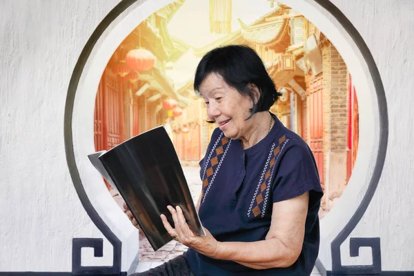 中国旧镇读杂志的老年妇女 — 图库照片