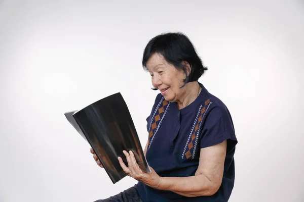 读白色背景杂志的老年妇女 — 图库照片