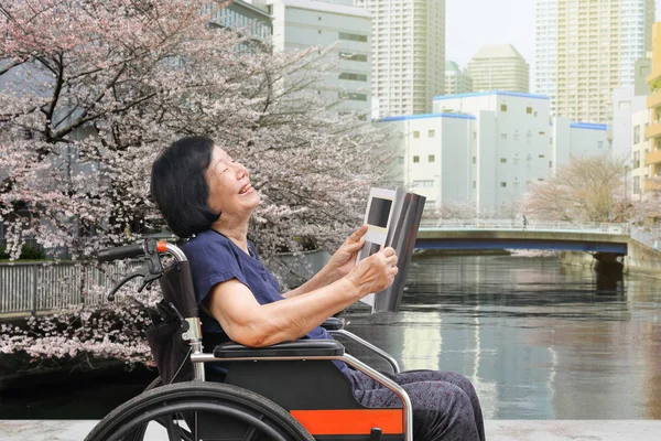 Senior Asian Woman Laughing While Reading Magazine Park — Stock Photo, Image