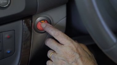 Yaşlı kadın el itme başlamak araba motoru düğme