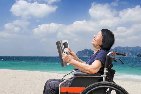 Senior Asian Woman Laughing While Reading Magazine Beach — Stock Photo, Image