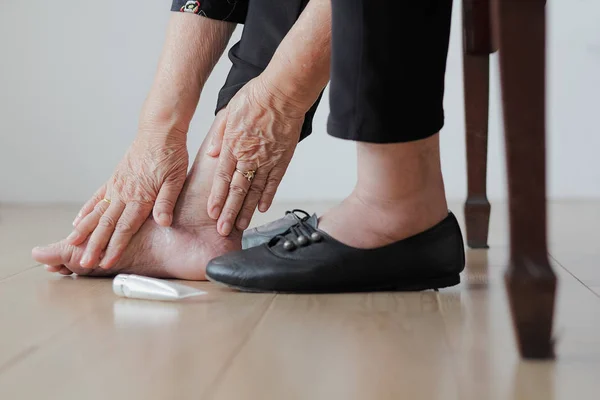 Mulher Idosa Colocando Creme Pés Inchados Antes Colocar Sapatos — Fotografia de Stock