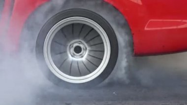 Sürüklenen yarış arabası başlangıç çizgisinde lastiği yakar