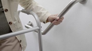 Küpeşte güvenliği için üzerinde tutan yaşlı kadın yürümek adımları