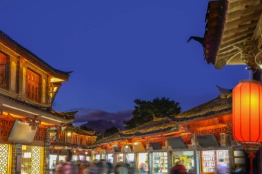 Akşam Lijiang 'ın eski kasabasında kargalı bir turist vardı..