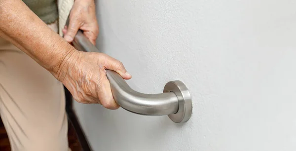 Donna anziana aggrappata al corrimano per scalini di sicurezza — Foto Stock