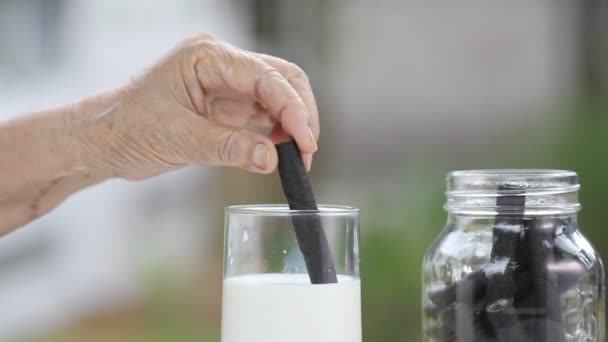 Tangan Tua Mencelupkan Kue Cokelat Dalam Gelas Susu — Stok Video