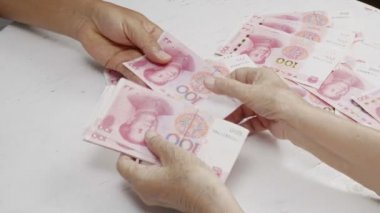 Çinli kıdemli kadın ödeme için para sayıyor.