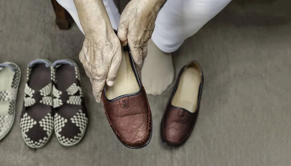 Mujer mayor poniéndose zapatos — Foto de Stock