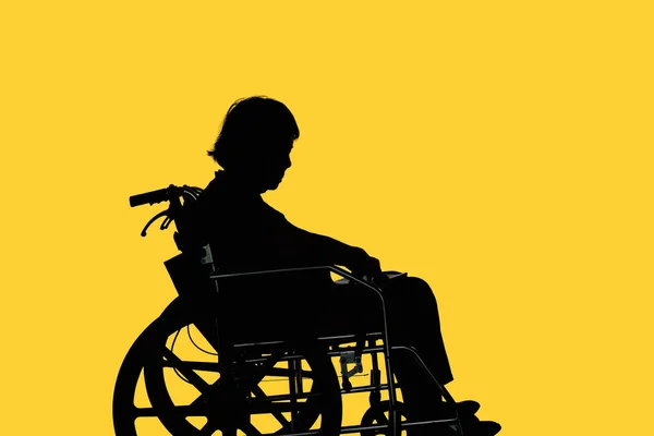 Silhouette of Disabled and dejected elderly woman sitting in her — Stock Photo, Image