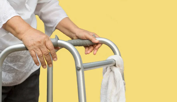 Senior vrouw met behulp van een walker cross street met verzorger — Stockfoto