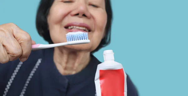Asiática anciana tratando de usar cepillo de dientes, temblor de manos. Dental — Foto de Stock