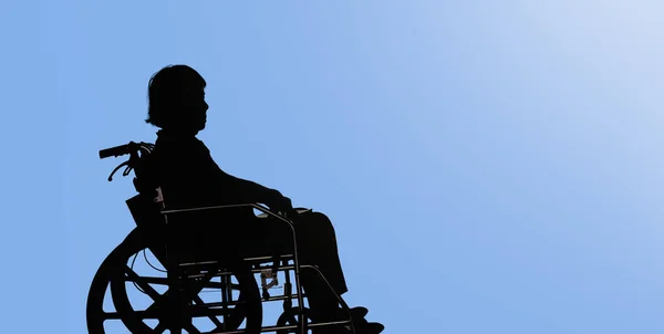 Silhouette of Disabled and dejected elderly woman sitting in her — Stock Photo, Image
