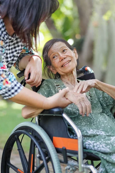 Äldre asiatisk kvinna på rullstol hemma med dottern ta bil — Stockfoto