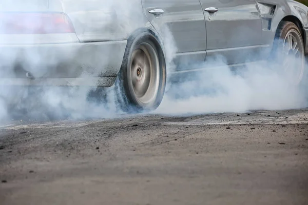 拖着赛车的汽车为了准备比赛而把轮胎上的橡胶烧掉了 — 图库照片