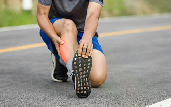 Male middle aged having a cramp while jogging. Stop and massage calf — Stock Photo, Image