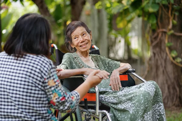 年长亚洲妇女坐在轮椅上与女儿照顾 — 图库照片
