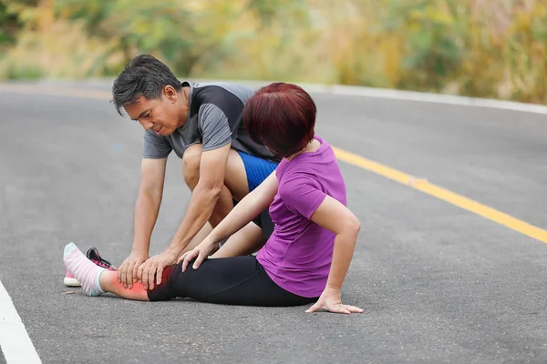 Kvinna medelålders med en kramp medan jogging, massage kalv — Stockfoto
