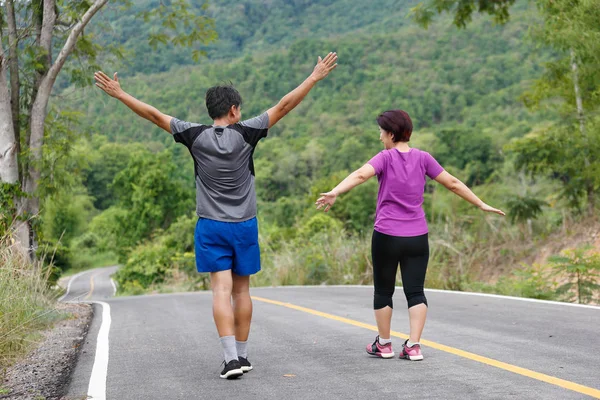 Asian Middle w wieku para rozciąganie mięśnie przed jogging w PA — Zdjęcie stockowe