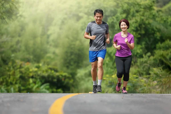 Asiatiska medelålders par jogging övning i parken — Stockfoto